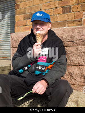 Mann saß ein Eis Stockfoto