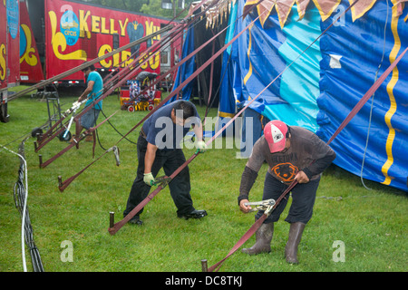 Arbeitnehmer, die ein Zelt im Regen für eine Aufführung des Kelly Miller Zirkus. Stockfoto