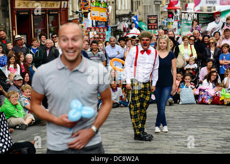 Royal Mile, Edinburgh, Schottland, Großbritannien, Montag, 12. August 2013. Street Performer Clown Comedian Pedro Tochas aus Portugal unterhält ein Publikum mit Hilfe von Publikum Freiwilligen während des Edinburgh International Festival Fringe Stockfoto