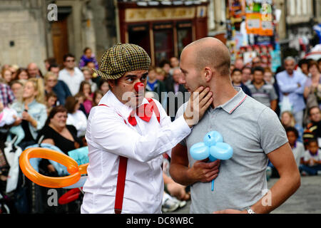 Royal Mile, Edinburgh, Schottland, Großbritannien, Montag, 12. August 2013. Street Performer Clown Comedian Pedro Tochas aus Portugal unterhält eine Menge mit Hilfe eines Publikums Freiwillige während des Edinburgh International Festival Fringe Stockfoto