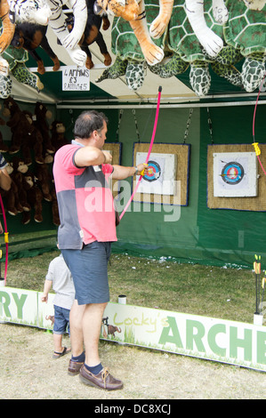 Mann, Pfeil und Bogen schießen, auf eine Bogenschießen Festplatz Stall in Swansea, Sommer 2013 Stockfoto