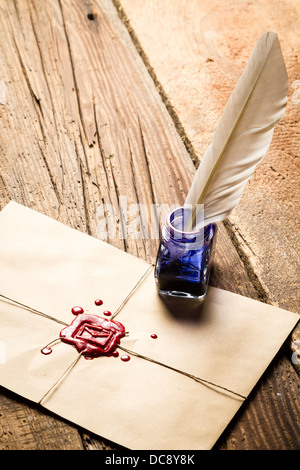 Blaue Tinte Tintenfass mit Feder auf Umschlag mit roten Dichtstoff Stockfoto