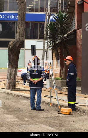 Bauarbeiter sprechen, zwischen ihnen eine Topcon Ebene. Renovierung der Larco Avenue in Miraflores, Lima, Peru Stockfoto