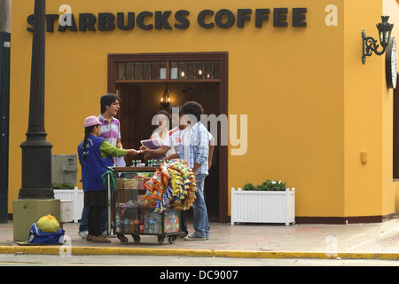 Straßenhändler mit einer kleinen Karre verkaufen Getränke und Snacks vor Starbucks-Kaffee in den Bezirk Barranco, Lima, Peru Stockfoto