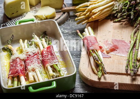 Zubereitung von Spargel, eingehüllt in Parma-Schinken mit Käse Stockfoto