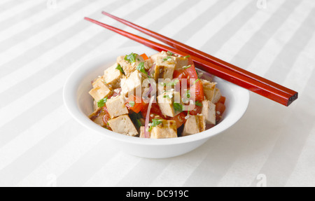 Tofu Salat - gegrillter Tofu warf zusammen mit Tomaten, Zwiebeln und Koriander. Stockfoto