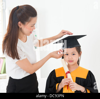 Asiatische Kind Graduierung, Lehrer Kappe für Schüler innen einstellen. Stockfoto