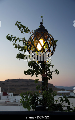 Blick über Lindos, Rhodos, Griechenland, vom Restaurant auf der Dachterrasse bei Sonnenuntergang, in der Nähe unter der Festung und die Akropolis von Lindos. Stockfoto