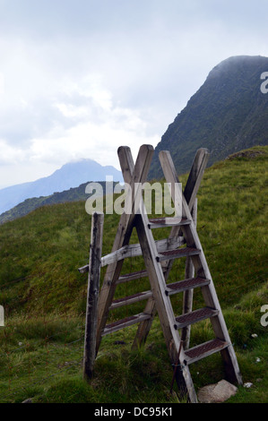 Eine hölzerne Leiter-Stil in der Nähe von The North Eastern Klippen von The Welsh Mountain Foel-Goch mit Tryfan in der Ferne Stockfoto