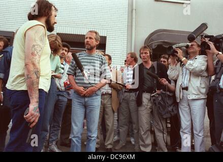 Entführer Hans-Jürgen Rösner (l) hält eine Pistole in der Hand und beantwortet die Fragen der Journalisten am 17. August 1988. Rösner und sein Komplize Dieter Degowski eine Bank in Gladbeck-Rentfort beraubt hatte und Geiseln am 16. August 1988 genommen hatte. Die beiden Täter wurden nach einer spektakulären Verfolgung festgenommen in welchen zahlreiche, die Medien Vertretungen beteiligt waren. Zwei Geiseln starben. Stockfoto