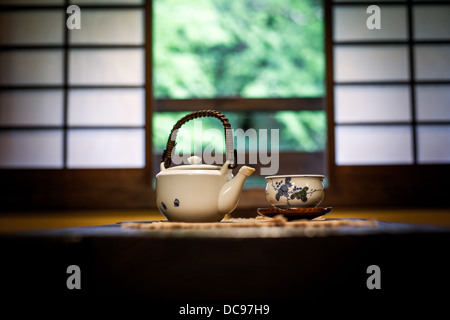 Teekanne und Tee Schale auf einem Tisch in einem traditionellen japanischen Zimmer vor Shoji Bildschirm windows Stockfoto