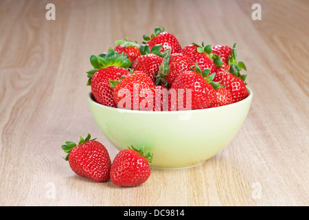 frische Erdbeeren in einer Platte auf dem Holztisch Stockfoto