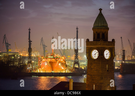 Der Wasserstand Turm von St. Pauli Landungsbrücken vor dem Trockendock von Blohm und Voss Shipyards mit dem Schiff Stockfoto