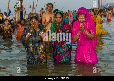 Frauen, die ein Bad in der Sangam, dem Zusammenfluss der Flüsse Ganges und Yamuna Saraswati, in den frühen Morgenstunden Kumbha Mela Stockfoto