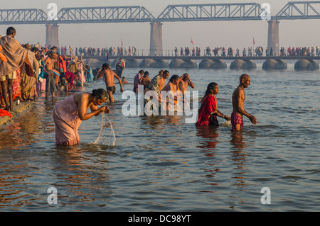 Massen von Menschen, die ein Bad in der Sangam, dem Zusammenfluss der Flüsse Ganges und Yamuna Saraswati, in den frühen Morgenstunden, Stockfoto