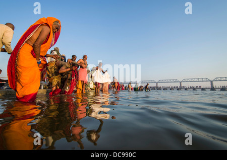 Massen von Menschen, die ein Bad in der Sangam, dem Zusammenfluss der Flüsse Ganges und Yamuna Saraswati, in den frühen Morgenstunden, Stockfoto