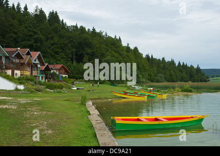 bunten Booten und Hütten am Ufer des Flusses Doubs, Lac Saint Point. Lac de Malbuisson Stockfoto