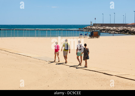 Vier Menschen auf Lattenrost Holz Zugang Rampe zum Strand von Cambrils < Spanien. Stockfoto