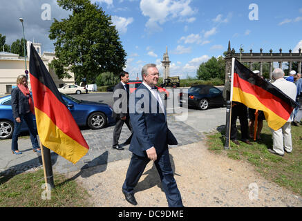 Berlin, Deutschland. 13. August 2013. Innenraum-Senator von Berlin Frank Henkel (vorne) geht durch deutsche Fahnen an der Glienicker Brücke während einer Veranstaltung der CDU zum 52. Jahrestag des Baus der Berliner Mauer 1961. Foto: RALF HIRSCHBERGER/Dpa/Alamy Live News Stockfoto