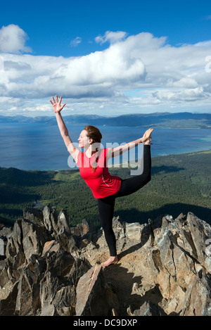 Eine Frau führt Yoga auf Mount Tallac mit Blick auf Lake Tahoe an einem schönen Nachmittag in der Nähe von South Lake Tahoe, CA. Stockfoto