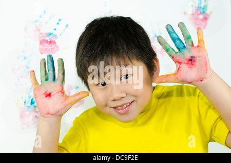 ein Kind malt mit seiner Hand auf einer weißen Wand Stockfoto