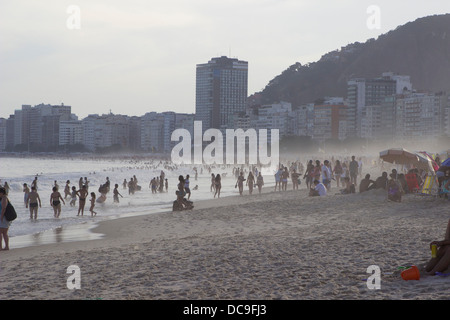 Menschen am Strand der Copacabana in der Abenddämmerung in Rio De Janeiro, Brasilien. Stockfoto
