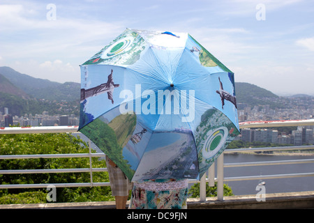 Ein Tourist mit einem Regenschirm mit Wahrzeichen Rio beim Sightseeing in Rio De Janeiro, Brasilien, Februar 2013. Stockfoto