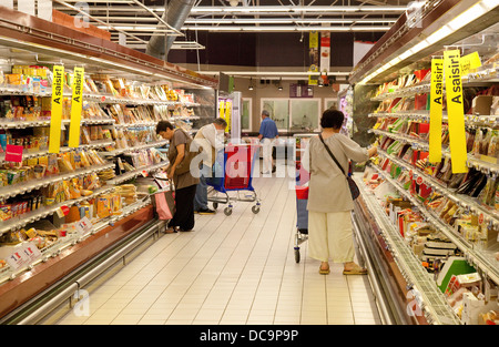 Supermarkt in Frankreich; die Menschen Einkaufen in einem Gang in einem französischen Supermarkt Carrefour, Frankreich, Europa Stockfoto