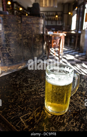 Glas Bier im Dorrego Cafe in San Telmo Viertel, Buenos Aires, Argentinien. Inschriften an antiken Holztisch bar Stockfoto