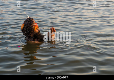 Sadhu, heiliger Mann, ein Bad zu nehmen und das beten in der Sangam, dem Zusammenfluss der Flüsse Ganges und Yamuna Saraswati, kurz vor Stockfoto