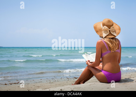 Frau im Bikini Buch am Strand lesen Stockfoto