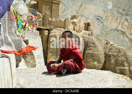 Ein Novize sitzt auf dem Felsen außerhalb des Lamayuru-Klosters Stockfoto
