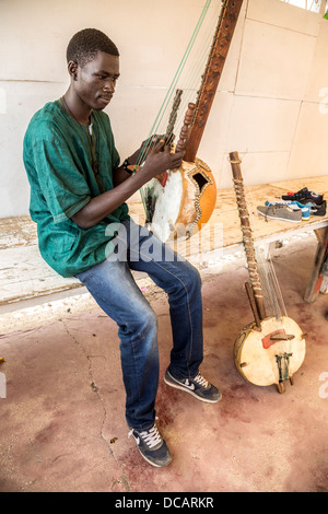 Junge Menschen spielen die Kora, ein Saiteninstrument der westlichen Sahelzone, hergestellt aus einer Kalebasse. Goree Island, Senegal. Stockfoto