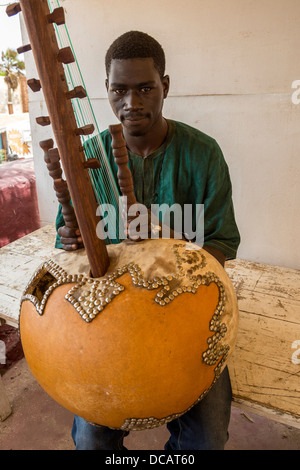 Junge Menschen spielen die Kora, ein Saiteninstrument der westlichen Sahelzone, hergestellt aus einer Kalebasse. Goree Island, Senegal. Stockfoto