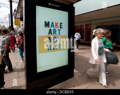 London 14.08.13: Besucher Abschnitt John Lewis Oxford Street kann man eine freie bildende Kunst-dia-Show mit freundlicher Genehmigung von der aktuellen Kunst überall-Projekt. Eine Bushaltestelle vor dem Geschäft hat eine rotierenden dia-Show von Plakaten mit so unterschiedlichen Künstlern wie Tracey Emin und Holbein der jüngere. Bildnachweis: Jeffrey Blackler/Alamy Live-Nachrichten Stockfoto