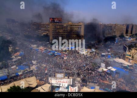 Kairo, Ägypten. 14. August 2013.  -Rauch steigt an Rabaa al-Adawya quadratischen folgenden Auseinandersetzungen zwischen Ägypter gestürzten Präsidenten Mursi und Riot Polizei in Kairo, Ägypten, 14. August 2013 unterstützen. Gewalt über viel von Ägypten verteilt, nachdem Polizei zwei Feldlager der Mursi Anhänger geräumt, Duschen Demonstranten mit Tränengas, wie der Klang der Schüsse Kredit klingelte: Ahmed Asad/APA Images/ZUMAPRESS.com/Alamy Live News Stockfoto