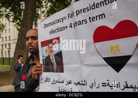 London, 14.08.2013, ein Pro-Mursi-Aktivist mit seinem Banner als Ägypter protestieren außerhalb Downing Street folgen, was sie sagen Massaker der Muslim-Bruderschaft Unterstützer gewesen, so dass "über 2.000" tot, wie Protestcamps um das Land wurden durch das Militär geräumt. Bildnachweis: Paul Davey/Alamy Live-Nachrichten Stockfoto