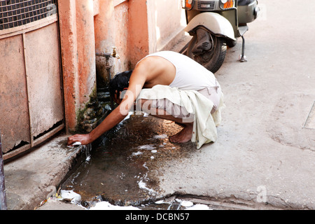 Ein indischer Mann wäscht in der Straße in Rishikesh, Indien Stockfoto