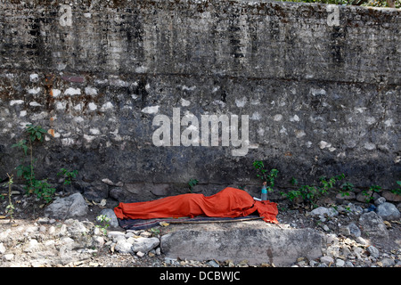 Ein Obdachloser liegt schlafend, sondern durch seine Decke vollständig bedeckt in Rishikesh, Indien. Stockfoto