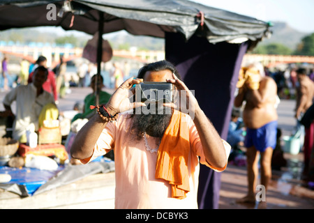 Ein Hindu Sadhu nimmt ein Foto mit seiner Kamera-Handy in Haridwar, Indien. Stockfoto