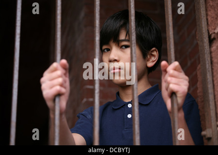 Junge stand hinter Gittern Stockfoto