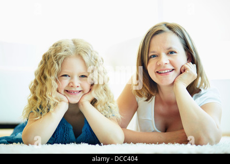 Porträt der glückliche Frau und ihre Tochter auf dem Boden liegend Stockfoto
