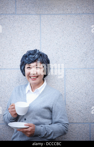 mittlere gealterte Frau mit einer Tasse Kaffee Stockfoto