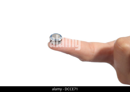 Frau Hand mit einer Knopfzelle mit dem Zeigefinger auf einem weißen Hintergrund isoliert Stockfoto