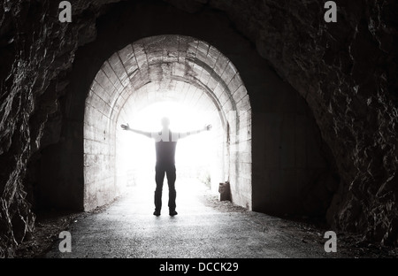 Der Mensch steht im dunklen Tunnel mit glühenden Ende Stockfoto