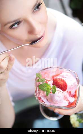 Nette Dame Essen eine Frucht-Eis dessert Stockfoto