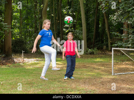 zwei junge Mädchen spielen Fußball im Hinterhof/Garten Stockfoto