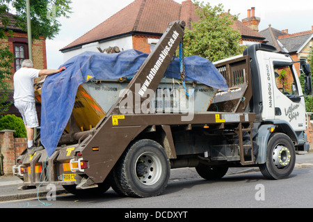 Treiber Belag Belastung fahren LKW mit Plane Blatt in einem Vorort Straße. Stockfoto