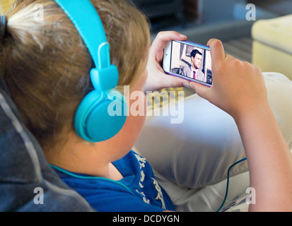 junge Mädchen beobachten Film / tv auf dem Smartphone Stockfoto