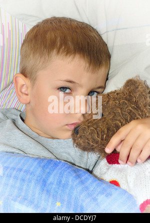 Kleiner Junge mit Teddybär Spielzeug im Bett Stockfoto